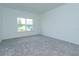 Simple bedroom with gray carpet and a large window at 5119 Firebush Dr, Apopka, FL 32712