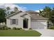 Two-story house with grey siding, two-car garage, and landscaped lawn at 5119 Firebush Dr, Apopka, FL 32712