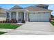 Inviting home boasting a spacious two-car garage, a well-maintained lawn, and a welcoming covered entrance at 5119 Firebush Dr, Apopka, FL 32712