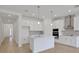 Bright and open kitchen features an island, stainless hood vent, and modern lighting fixtures at 5119 Firebush Dr, Apopka, FL 32712