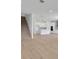 Open-concept living space showcasing modern kitchen, staircase, and light, wood-look flooring at 5119 Firebush Dr, Apopka, FL 32712