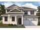 Two-story house with a neutral color scheme and a three-car garage at 5155 Firebush Dr, Apopka, FL 32712