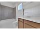 Bright bathroom featuring a tub with gray tile surround, white marble floors, and a wood vanity at 5155 Firebush Dr, Apopka, FL 32712