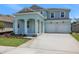 Charming two-story home features a two-car garage and landscaped front yard, creating appealing curb appeal at 5155 Firebush Dr, Apopka, FL 32712
