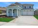 Charming two-story home features a two-car garage and landscaped front yard, creating appealing curb appeal at 5155 Firebush Dr, Apopka, FL 32712