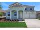 Charming two-story home features a two-car garage and landscaped front yard, creating appealing curb appeal at 5155 Firebush Dr, Apopka, FL 32712