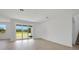 A spacious living room with a sliding glass door and luxury vinyl flooring at 5155 Firebush Dr, Apopka, FL 32712