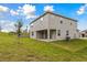 Two-story house with covered patio, grassy yard, and a partially visible fence at 5191 Firebrush Dr, Apopka, FL 32712