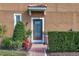 Townhome's front entrance with a decorative door, brick walkway, and lush greenery at 5448 Via Appia Way, Sanford, FL 32771