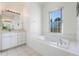 Bathroom with soaking tub, vanity, and large mirror at 5502 Bounty Cir, Tavares, FL 32778