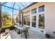 Relaxing screened patio with table and chairs, overlooking the backyard at 5502 Bounty Cir, Tavares, FL 32778