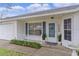 House exterior with a light blue front door and landscaping at 5530 Tangelo St, Leesburg, FL 34748