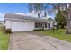 Front view of a single story home with attached garage and driveway at 5530 Tangelo St, Leesburg, FL 34748