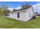 Rear view of a white single story home with screened porch at 5530 Tangelo St, Leesburg, FL 34748