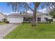 White single story home with attached garage and manicured lawn at 5530 Tangelo St, Leesburg, FL 34748