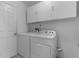 Laundry room with washer, dryer, and overhead cabinets at 5530 Tangelo St, Leesburg, FL 34748