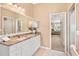 Elegant bathroom with granite countertops, white cabinets, and a large mirror at 6216 Landings Blvd, Lady Lake, FL 32159