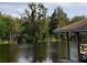 Private waterfront dock with covered boathouse and calm waters at 6216 Landings Blvd, Lady Lake, FL 32159