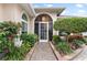 Elegant entryway with a screened door and lush landscaping at 6216 Landings Blvd, Lady Lake, FL 32159