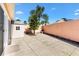 A cozy backyard featuring a concrete patio, storage shed, and mature landscaping against a blue sky at 629 Nuevo Leon Ln, The Villages, FL 32159