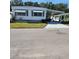 White single-wide manufactured home with carport and small yard at 7 Cocos Plumosa Dr # A, Eustis, FL 32726