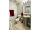 Clean bathroom with pedestal sink, toilet, and red towels at 762 Squirrel Ct, Kissimmee, FL 34759