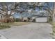 Landscaped front yard with mature trees and a paved driveway at 7798 Snowberry Cir, Orlando, FL 32819