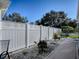 Landscaped backyard with a white vinyl fence and a gravel pathway at 8480 Se 167Th Forsyth St, The Villages, FL 32162