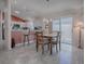 Dining area with wood table and chairs near kitchen and sliding doors at 8480 Se 167Th Forsyth St, The Villages, FL 32162