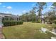 Landscaped backyard with spacious lawn and screened patio at 9033 Laurel Ridge Dr, Mount Dora, FL 32757