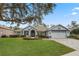 One-story home with a nicely landscaped yard and a two-car garage at 9033 Laurel Ridge Dr, Mount Dora, FL 32757