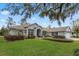 One-story house with lush landscaping and a large tree in the front at 9033 Laurel Ridge Dr, Mount Dora, FL 32757