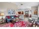 Open Gathering room with comfortable seating, red rug and views into the kitchen at 9033 Laurel Ridge Dr, Mount Dora, FL 32757