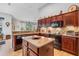 Well-equipped kitchen with granite countertops, dark wood cabinets and an island at 9033 Laurel Ridge Dr, Mount Dora, FL 32757