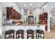 Granite kitchen island with seating, dark wood cabinets, and stainless steel appliances at 9033 Laurel Ridge Dr, Mount Dora, FL 32757