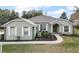 One-story house featuring gray siding, white shutters, and a well-maintained lawn at 9320 County Road 125B, Wildwood, FL 34785