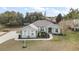 Single-story house with a gray exterior, white shutters, and a landscaped yard at 9320 County Road 125B, Wildwood, FL 34785