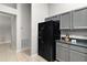 Black refrigerator and gray cabinets in a spacious kitchen at 9320 County Road 125B, Wildwood, FL 34785