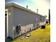 Side view of the house showing tan vinyl siding and landscaping at 9616 Se 168Th Elderberry Pl, The Villages, FL 32162