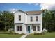 Charming two-story home featuring bright white siding and a welcoming turquoise front door, nestled in a landscaped yard at 9918 Fiddley Aly, Orlando, FL 32827