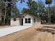 Exterior view of a newly built home with fresh concrete driveway surrounded by natural vegetation at Lot 42 Indian Estates Cr 423, Lake Panasoffkee, FL 33538