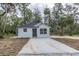 Charming single-story home featuring a concrete driveway and surrounded by lush trees at Lot 42 Indian Estates Cr 423, Lake Panasoffkee, FL 33538