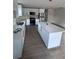 Modern kitchen featuring white cabinets, an island, stainless steel appliances, and hardwood flooring at Lot 42 Indian Estates Cr 423, Lake Panasoffkee, FL 33538