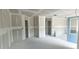 Unfinished living room showcasing fresh drywall, multiple doorways, and a large blue door, ready for customization at Lot 42 Indian Estates Cr 423, Lake Panasoffkee, FL 33538