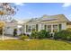 White house with green shutters, landscaped lawn, and a two-car garage at 16967 Se 93Rd Cuthbert Cir, The Villages, FL 32162