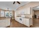 Kitchen with white cabinets, wood flooring, and island at 16967 Se 93Rd Cuthbert Cir, The Villages, FL 32162