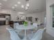 Modern breakfast nook with white table and chairs, offering views to the kitchen and living room at 5911 Delphina Loop, The Villages, FL 32163