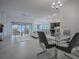 Open concept living and dining area with modern glass table and chairs at 5911 Delphina Loop, The Villages, FL 32163