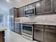 Modern kitchen with stainless steel appliances and dark wood cabinets at 5911 Delphina Loop, The Villages, FL 32163