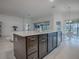 Modern kitchen island with dark brown cabinets, quartz countertop, and stainless steel appliances at 5911 Delphina Loop, The Villages, FL 32163